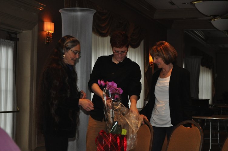 Jane & Alex giving Pat an orchid as thanks for organizing the fundraiser